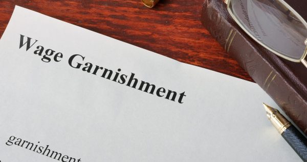 Wage Garnishment definition written on a paper.